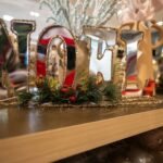 a wooden shelf topped with christmas decorations and letters