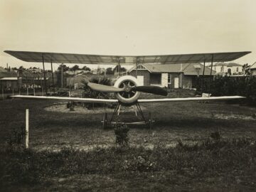 grayscale photography of biplane on field