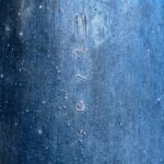 a close up of a metal surface with water drops