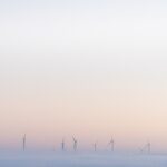 a group of windmills in a foggy field