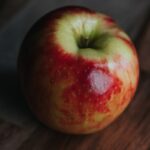 red apple fruit on brown wooden table