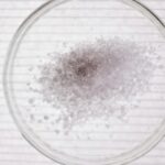 High-angle view of salt crystals in a petri dish, perfect for science stock images.