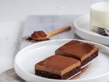 Enjoy these gourmet chocolate cake bars with a cocoa powder dusting, perfect for dessert lovers.