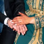 Close-up of hands with intricate henna designs and traditional Moroccan attire, symbolizing love.