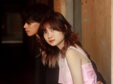 A young couple shares a tender moment indoors, capturing love and connection.