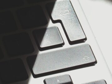 Dramatic light and shadow on a laptop keyboard, emphasizing texture and contrast.