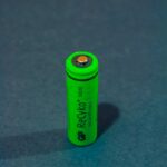 Vertical close-up of a green rechargeable battery highlighting power and sustainability.