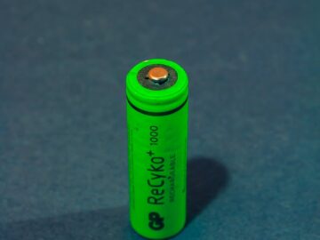 Vertical close-up of a green rechargeable battery highlighting power and sustainability.