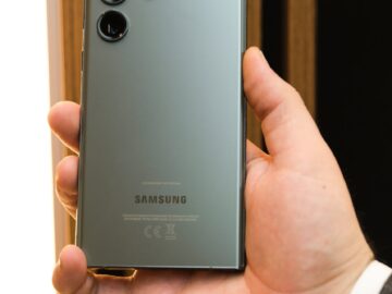 Close-up of a person holding a sleek Samsung smartphone with a triple camera setup.