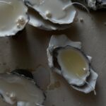 Artistic shot of opened oysters revealing pearls, emphasizing texture and contrast.
