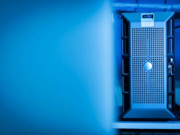 Close-up of a modern server unit in a blue-lit data center environment.