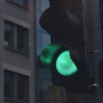 A close-up of a green traffic light in a city street scene.