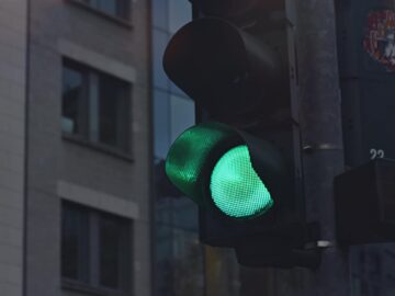 A close-up of a green traffic light in a city street scene.