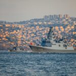 Turkish Navy warships navigate the Bosporus during a sunny day with Istanbul's skyline in the background.