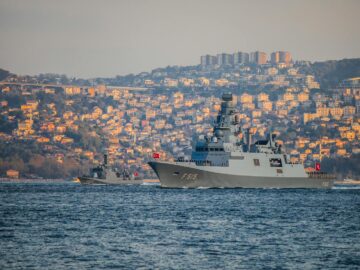 Turkish Navy warships navigate the Bosporus during a sunny day with Istanbul's skyline in the background.