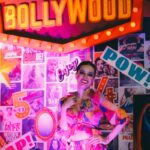 Colorful portrait of a woman in Bollywood-themed setting with vibrant lights.