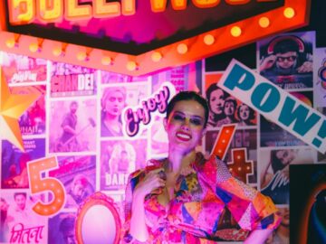 Colorful portrait of a woman in Bollywood-themed setting with vibrant lights.