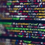 Vivid, blurred close-up of colorful code on a screen, representing web development and programming.