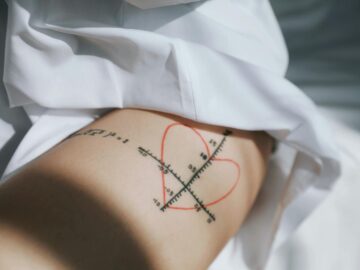 Close-up of a unique tattoo featuring a math graph and heart shape on a person's thigh.