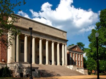 Historic neoclassical university library with columns on a sunny day.