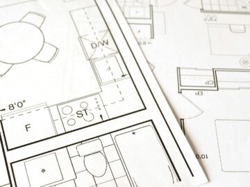 Close-up view of an architectural floor plan on paper showcasing detailed room layouts and measurements.