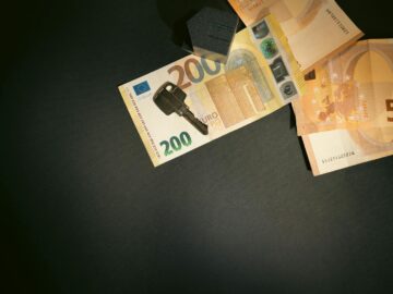 Flat lay of a house key on Euro bills representing real estate investment and finance.