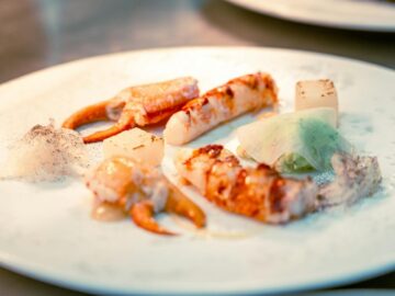 Elegant seafood dish featuring crab claws, lobster, and creative plating, ideal for fine dining contexts.