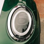 Detailed view of a retro car headlight with chrome trim showcasing modern design elements.