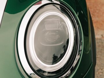 Detailed view of a retro car headlight with chrome trim showcasing modern design elements.