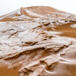A captivating sandy dune covered in frosty patterns, showcasing nature's unique beauty.