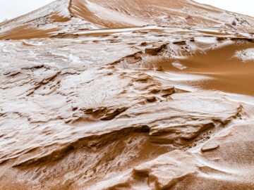 A captivating sandy dune covered in frosty patterns, showcasing nature's unique beauty.