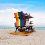Vibrant rainbow lifeguard tower on Miami Beach, perfect for summer travel imagery.