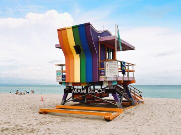 Vibrant rainbow lifeguard tower on Miami Beach, perfect for summer travel imagery.