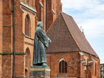 Statue of Martin Luther in front of a historic church, symbolizing the Reformation.