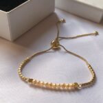 Minimalist bracelet with delicate pearls and gold chain, perfect for chic fashion.