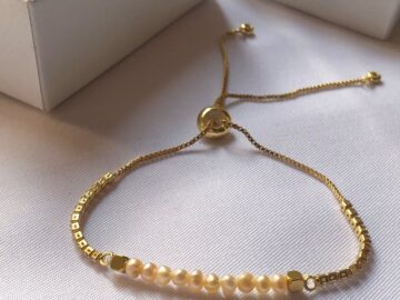Minimalist bracelet with delicate pearls and gold chain, perfect for chic fashion.