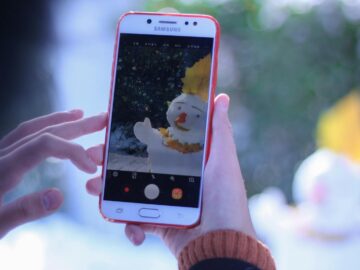 A smartphone captures an artistic photo of a snowman during winter.