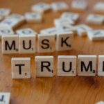 Scrabble game tiles notably spell out 'Musk' and 'Trump' on a wooden table, sparking cultural conversation.