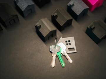 Miniature house models and keys symbolize real estate investment and housing market.