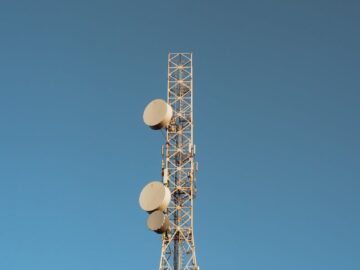 A telecommunication tower stands tall against a clear blue sky in Bình Thuận, Vietnam.