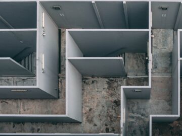 Aerial view of a complex indoor labyrinth made of concrete walls.