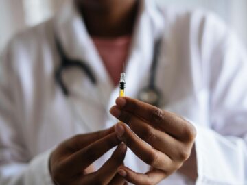 Close-up of a healthcare professional holding a syringe, symbolizing medical care and vaccination.