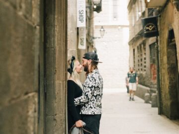 A couple shares an intimate moment on a city street with their dog.
