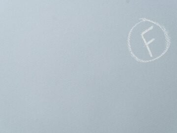 Chalk-written F grade encircled on a textured light blue surface.