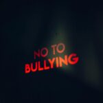 Image featuring a strong anti-bullying message boldly lit on a dark background.
