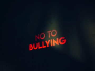 Image featuring a strong anti-bullying message boldly lit on a dark background.