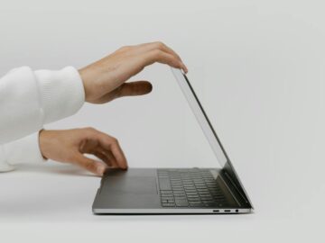 Minimalist photo showing hands opening a sleek laptop, perfect for technology and lifestyle themes.