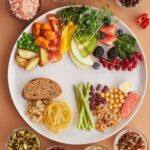 A vibrant assortment of healthy foods on a plate, showcasing a balanced diet with fruits, vegetables, nuts, and grains.