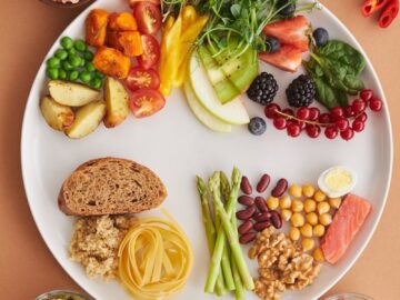 A vibrant assortment of healthy foods on a plate, showcasing a balanced diet with fruits, vegetables, nuts, and grains.