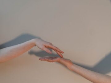 Close-up of two hands reaching towards each other, symbolizing connection.